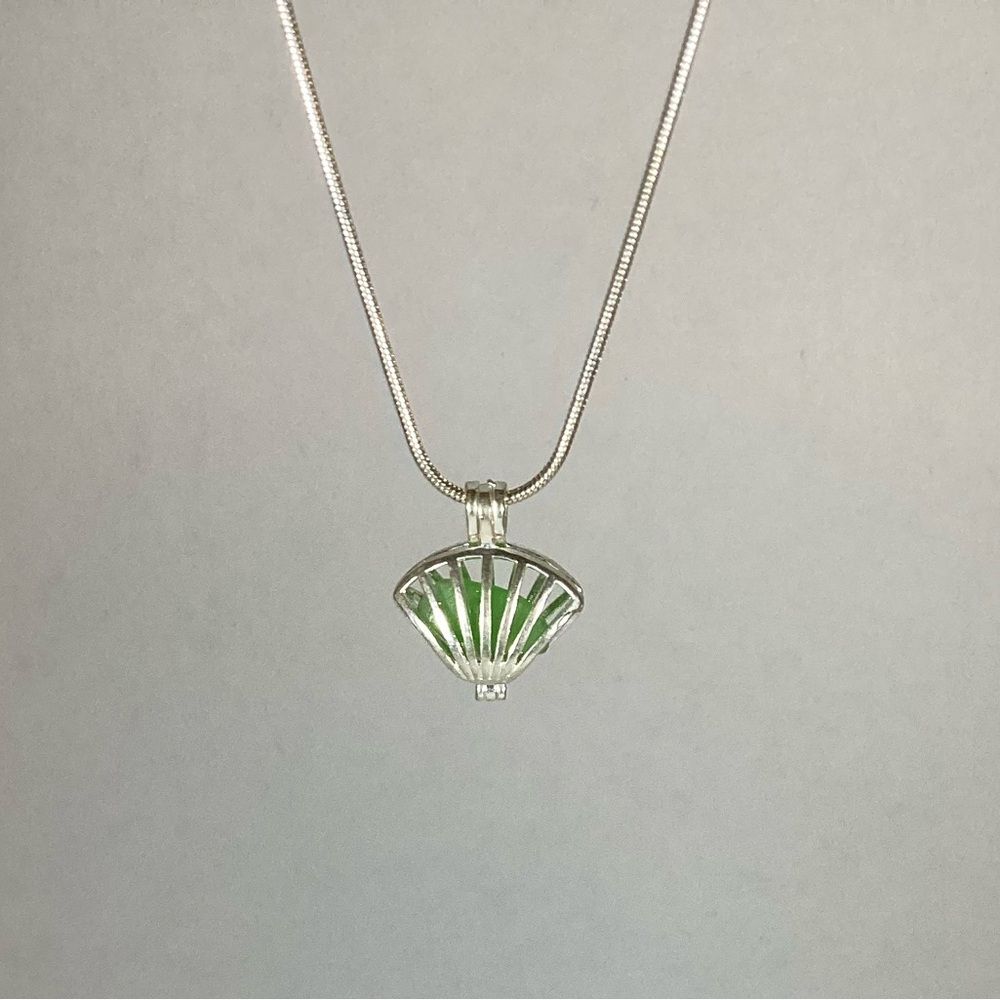 Green sea glass necklace in silver sea shell locket